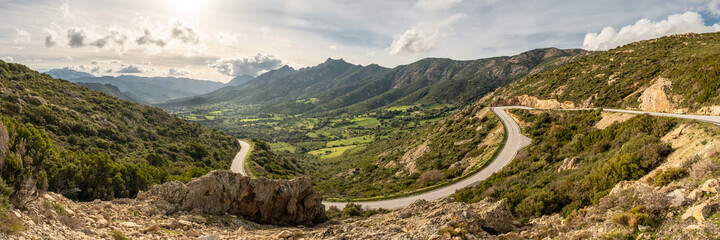 Fototapeta na wymiar Road leading to green valley and mountains in Corsica