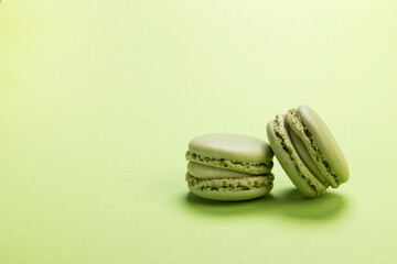 Pistachio flavor macaron cookies on pastel green colored background