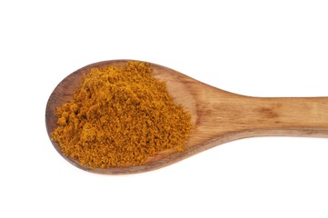 Curry en poudre dans une cuillère en bois sur fond blanc