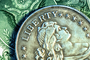 Close up one Dollar bill and coin with description: Liberty. Horizontal image.