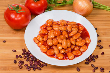 Beans stewed with tomato sauce on dish among the ingredients