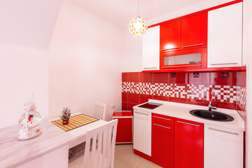Red white kitchen interior in hotel apartment