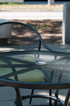 Metal table with a glass top and an openwork metal garden chair