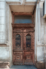 Old house facade, cracked red paint on the old vintage wooden door