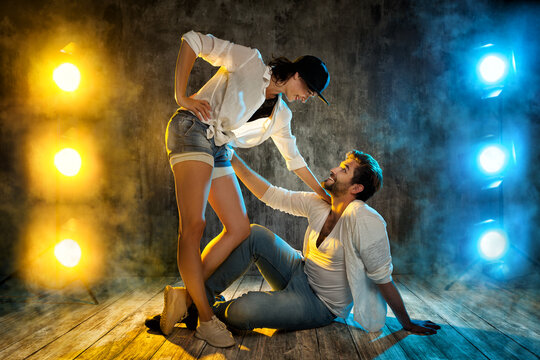 Hip Hop Dancing Couple. Happy Smiling Modern Break Dancer In White Shirt And Jeans. Sexy Man And Woman Dance Over Grunge Background