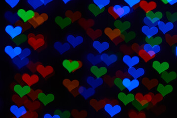 Multicolored hearts bokeh on black background