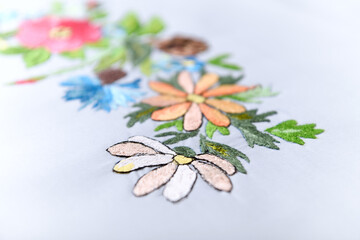 Embroidery with colorful flowers. Close up. Copy space.