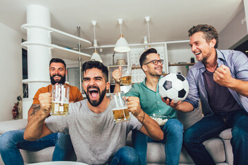 Group of football fans watching soccer game on television and celebrating goal.
