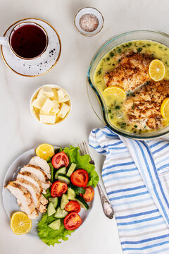 Chicken breasts with lemon sauce. Sliced chicken and fresh vegetable salad. Healthy lunch menu. 