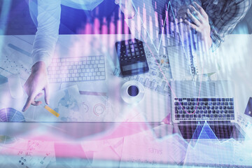 Double exposure of man and woman working together and financial graph hologram drawing. market analysis concept. Computer background. Top View.