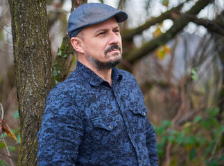 Farmer leaning against tree