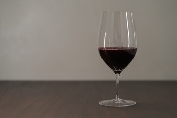 Red wine in thin wine glass on wood table