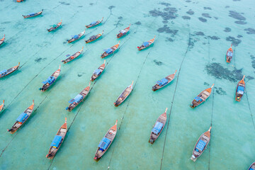 Stunning summer landscape. Aerial view of fishing long tail boat group in turquoise Andaman sea at Koh Lipe or Lipe island, Satun, Southern Thailand. Shot from drone