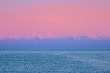Natural background of magenta. The sea under the clouds. Fantastic Arctic purple evening minimalistic seascape.