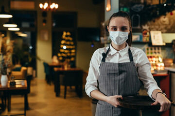 woman waitress posing in cafeteria with protective face mask - obrazy, fototapety, plakaty