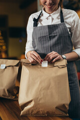 woman waitress preparing take away food in restaurant