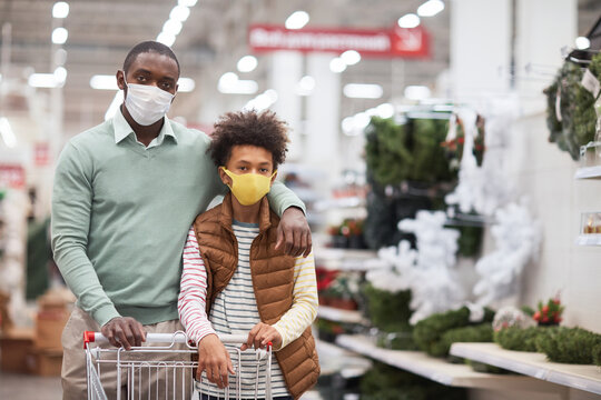 Waist Up Portrait Of African-American Family Wearing Masks In Supermarket And Looking At Camera While Posing With Shopping Cart, Copy Space