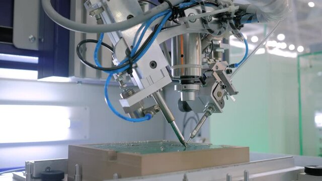 Process of selective soldering components to printed circuit board at factory, exhibition - close up view. Automated technology, industrial, robotic, electronic, production, manufacturing concept