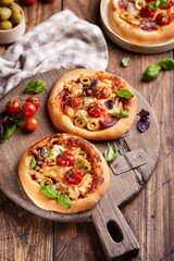 Mini Pizza with tomatoes, chicken, red onion, olives and mozzarella cheese. Delicious homemade pizzetta. Italian cuisine.
