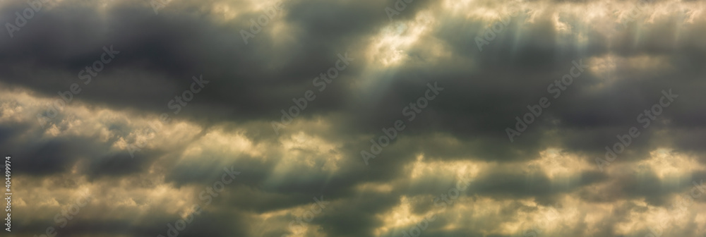 Wall mural panorama sun rays of light shining through dark clouds 