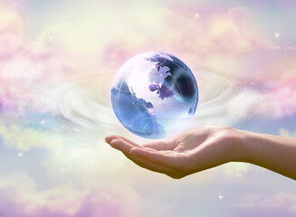 Earth Day or Environment Day concept. Clean air, World Ozone Day theme. Blue globe in human hand on cloudy sky background. Saving Planet, save, protect green nature and ecology, sustainable lifestyle.