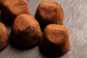 Chocolate truffel candy on black surface close up