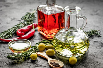 jar with oil with chili on stone table background
