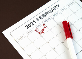 Groundhog Day concept. The word Again is written on the calendar on the date 02 February. Brown background.