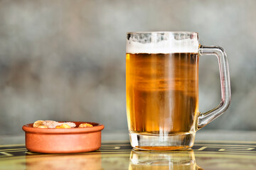 Beer with tapas on a side on table isolated  with blurred background