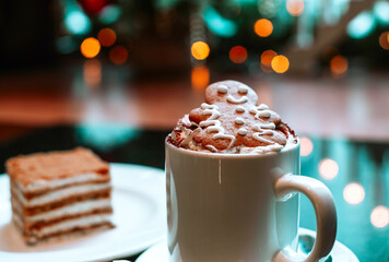 cappuccino with gingerbread man and honey cake on the background of Christmas lights
