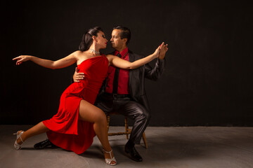 Fototapeta na wymiar Pareja profesional de Tango bailando, en estudio, de forma pasional y sensual