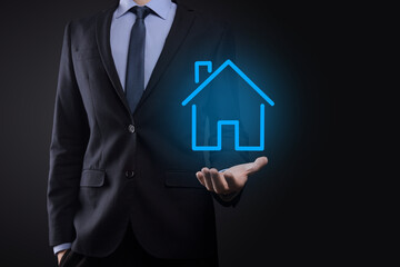 Fototapeta na wymiar Real estate concept, businessman holding a house icon.House on Hand.Property insurance and security concept. Protecting gesture of man and symbol of house.