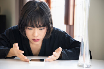 Angry upset asian woman with smartphone, problem concept of online shopping, distant togetherness, online deal, smartphone app transaction, tele medicine, new normal video call, social distancing