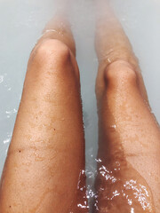 Female legs in the bathtub personal perspective view