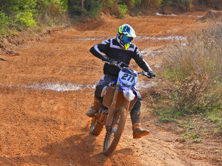 Zoom photo of professional motocross rider on his motorcycle on extreme dirt and mud terrain track....