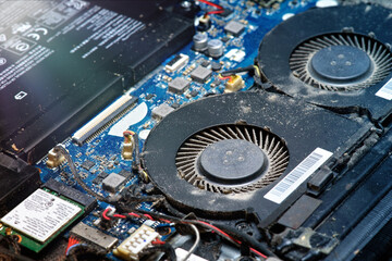 Dusty fan inside the laptop during servicing. Selective focus. close up, macro.