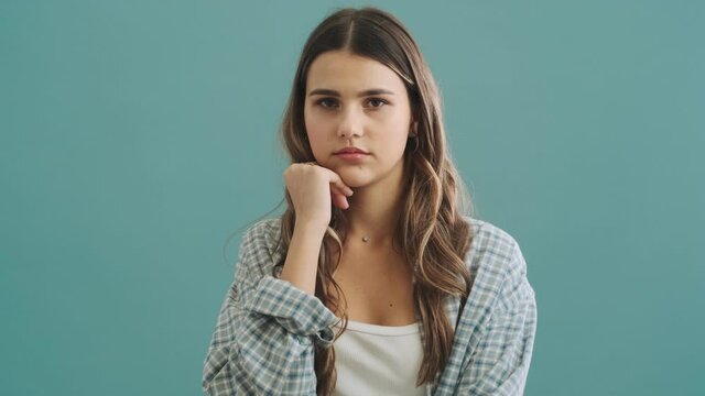 A bored woman is yawning standing isolated over blue background