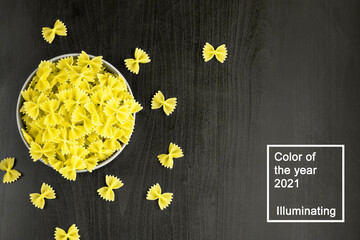 Top view of black background with italian raw farfalle or pasta in bowl with copy space. Color of the year 2021