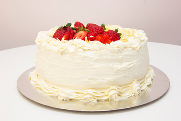 White cake with strawberry icing and pieces of white chocolate
