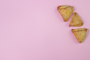 Sweet pastries on a pink background. Homemade sweets. Baking with sesame seeds. There is a place for an inscription or logo
