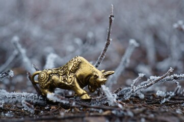 Fototapeta premium Figure of a metal bull on a background of frost.