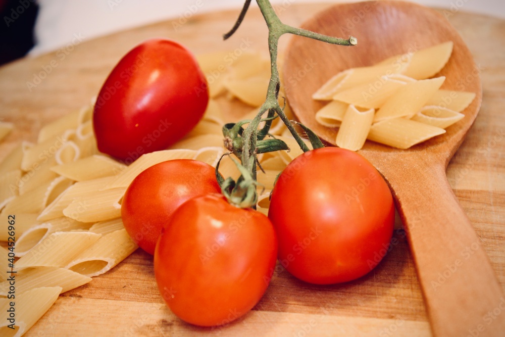 Wall mural uncooked pasta italian pasta raw pasta with vegetables on table