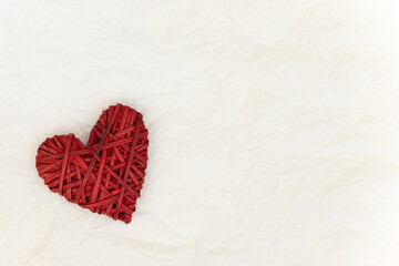 Wicker red heart decor on a light background with place for text.