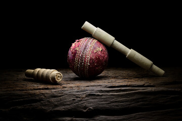 Cricket ball and bails still life close-up on a highly texture wooden surface.  - 404532363