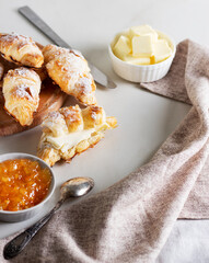 Fresh croissants with butter and orange jam. 