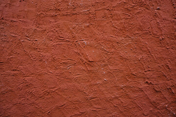 Red textured with cracks of a wall close-up. Industrial background. Copy space