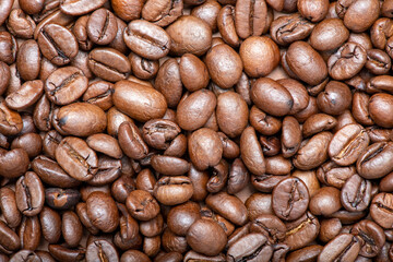 Fresh coffee beans scattered as a background or texture.