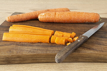 carote tagliate su tagliere di legno su tavolo della cuina altra vista