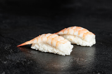 Sushi set of nigiri from salmon, tuna, shrimp, smoked eel, sea bass on black background. Traditional