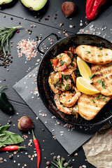 Prawns Shrimps roasted in garlic butter with lemon and parsley on wooden background. Healthy food.